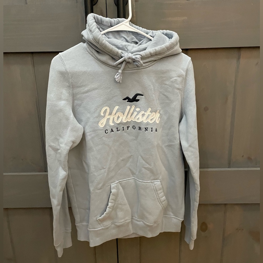 Hollister 
Baby blue hoodie with logo 
Size M